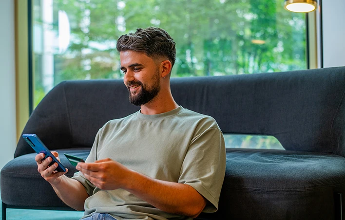 Un homme effectue un paiement en ligne par carte sur son smartphone