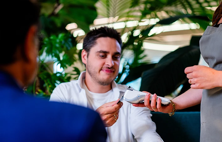 Un homme paye sur un terminal de paiement