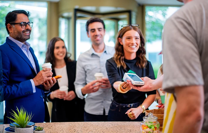 Un groupe de personnes paye sur un terminal de paiement