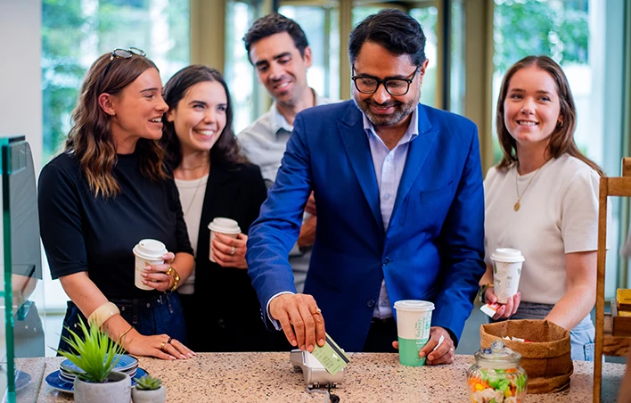 Un groupe de personne paye son café sur un TPE