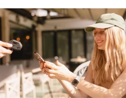 Une femme paye avec son smartphone sur un TPE