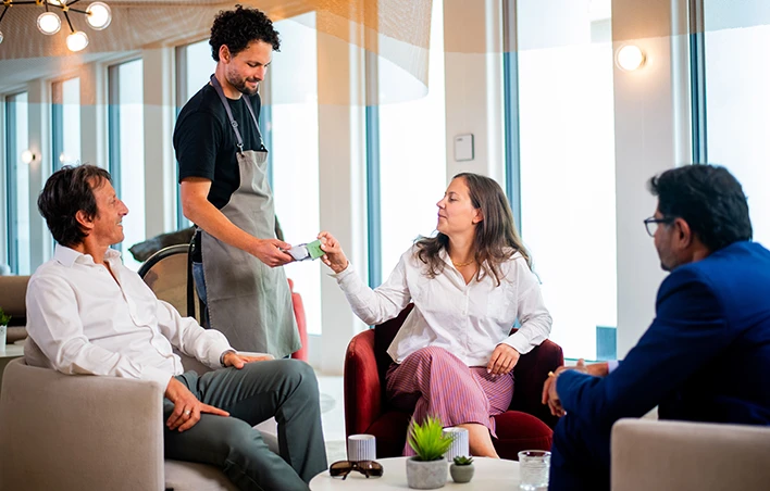 Un commerçant présente son DAB afin que le client puisse régler